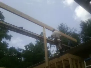 Carpenter setting a ridge beam over a new addition frame — Ice Dam Removal by Roofing Brothers in Paton