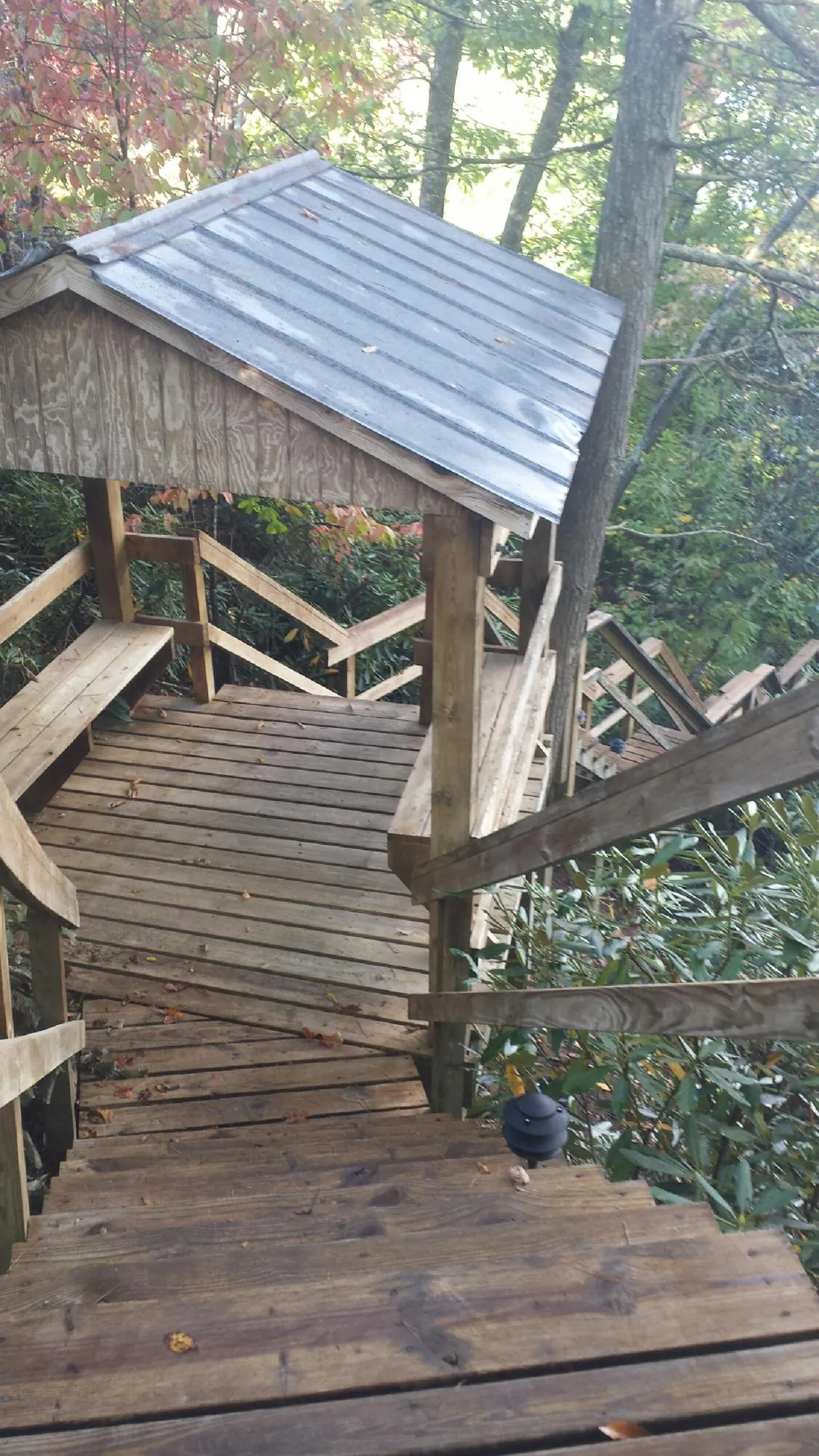 Metal roofed shelter over wooden steps on a wooded walkway — Skylight Repair & Installation work by our crew in Paton