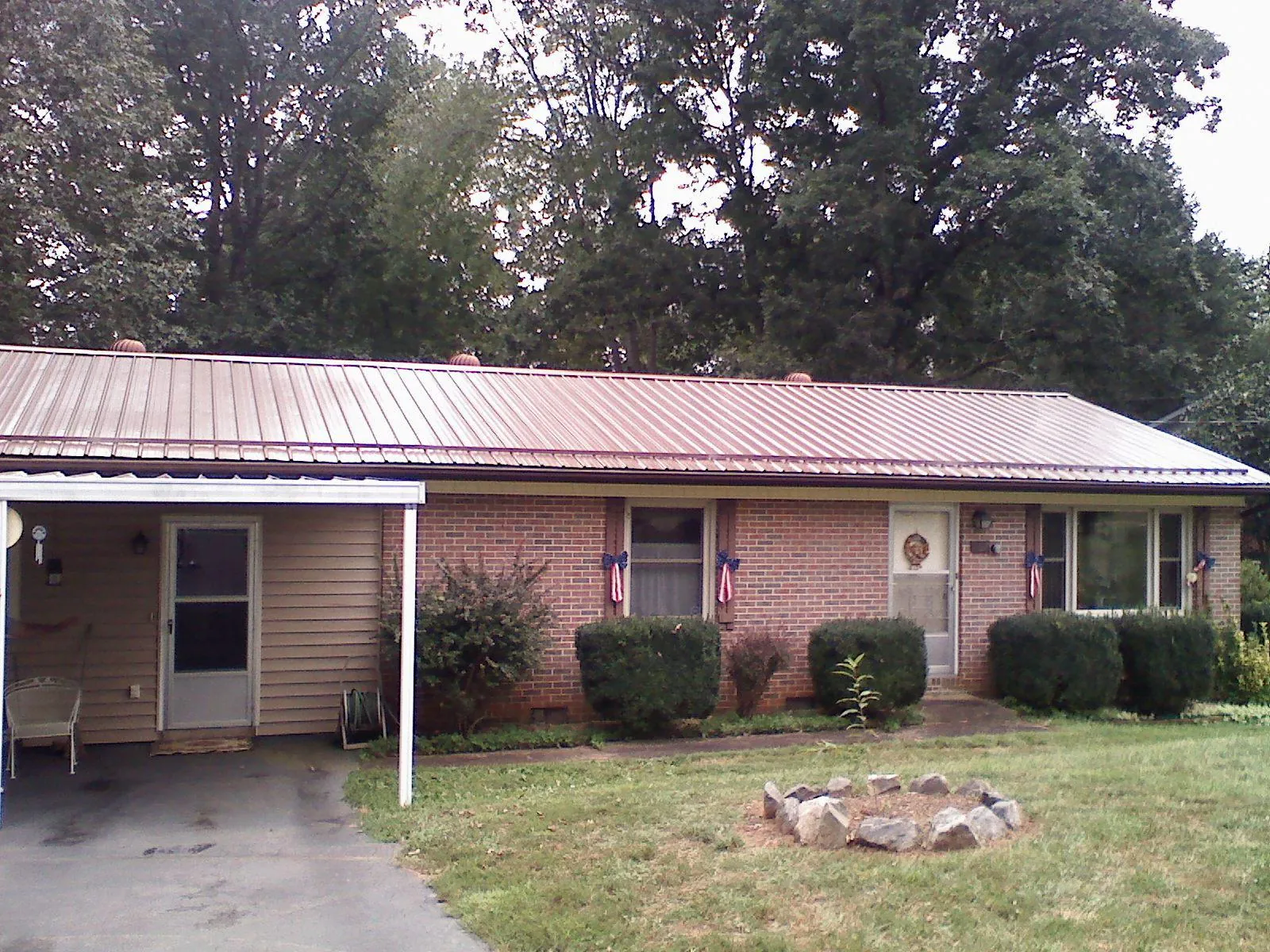 Bronze metal roof and carport on a brick ranch home — Roof Repair work by our crew in Paton