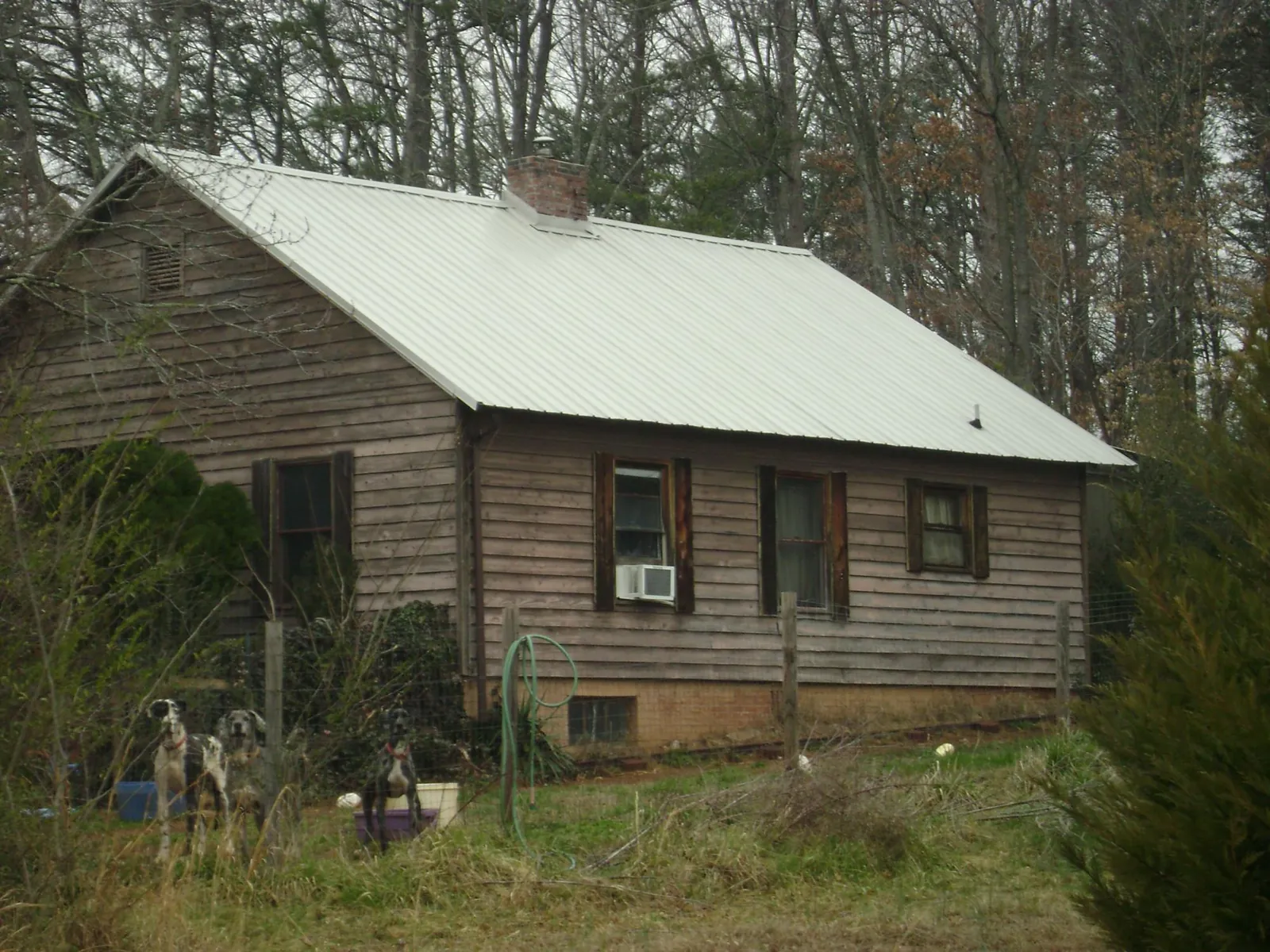 White metal roof on an old wood sided farmhouse, from a Metal Roof Installation job in Paton